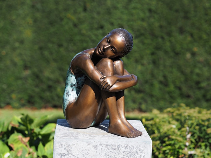 Bronze sculpture of a young girl in swimsuit resting her head