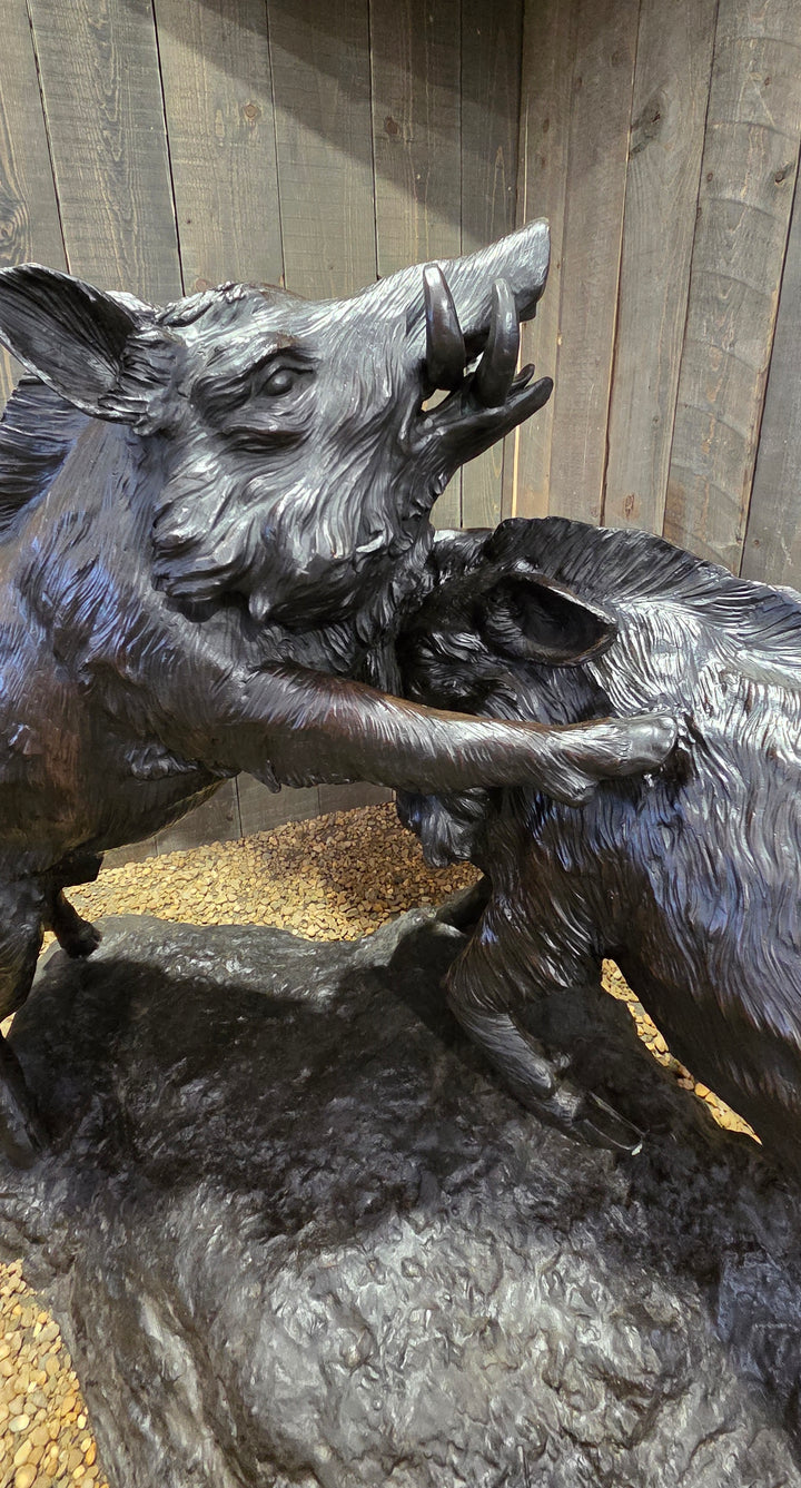 Lifesize bronze sculpture of two fighting wild boars