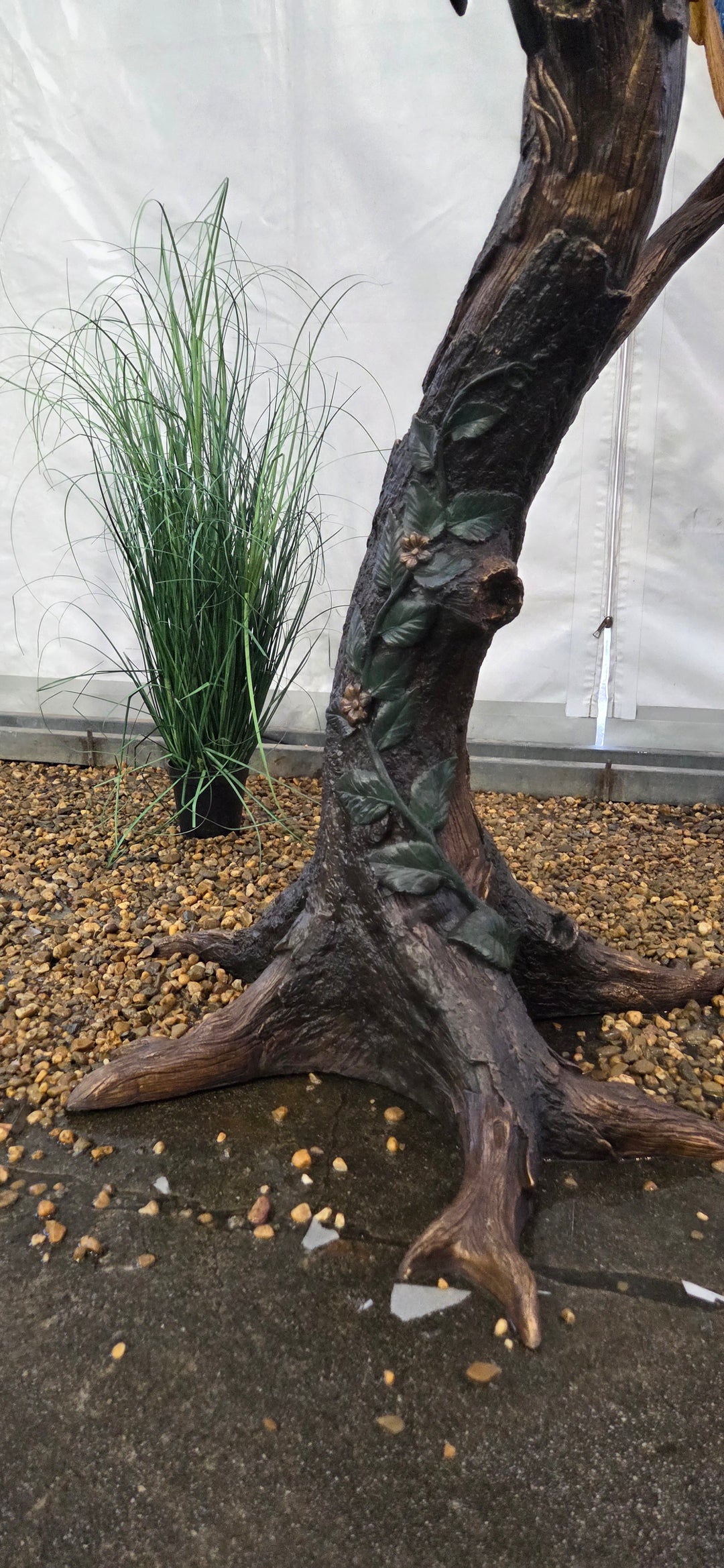 Lifesize bronze sculpture of a macaw sitting on a branch