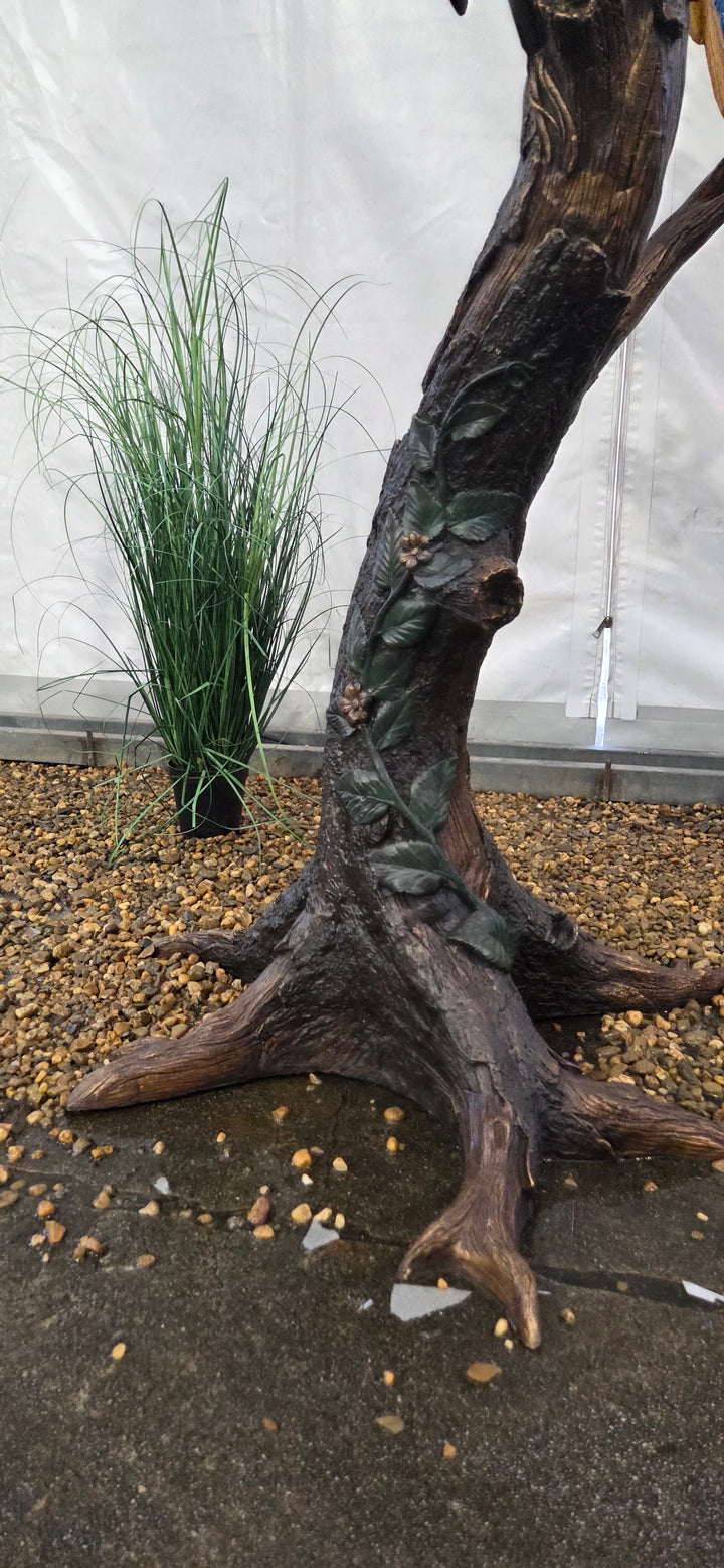 Lifesize bronze sculpture of a macaw sitting on a branch