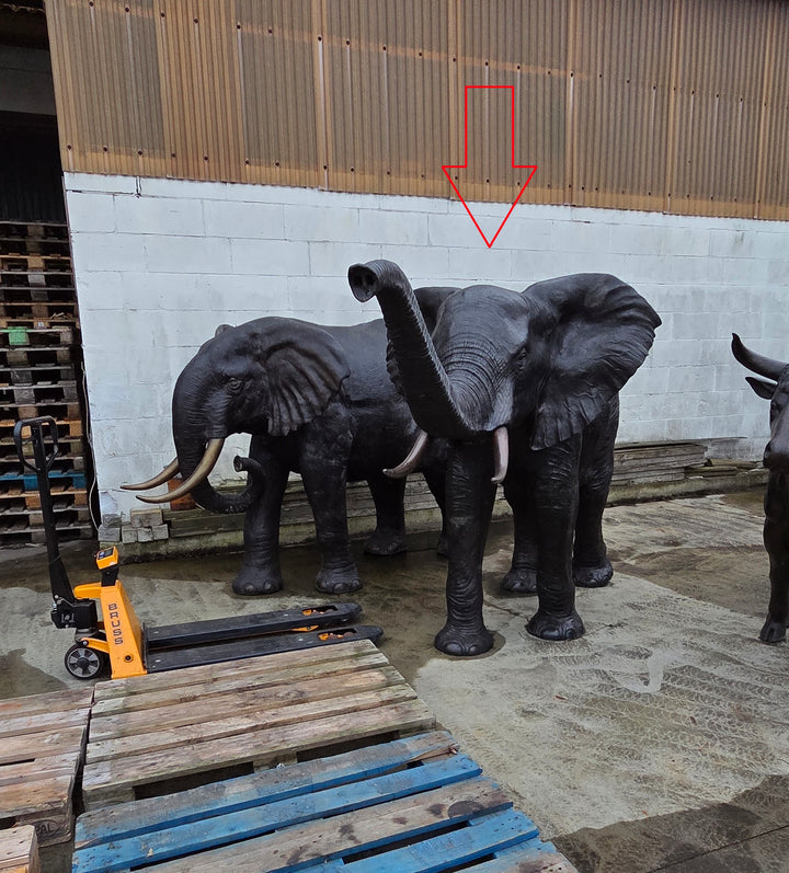 Lifesize bronze sculpture of an elephant with raised trunk