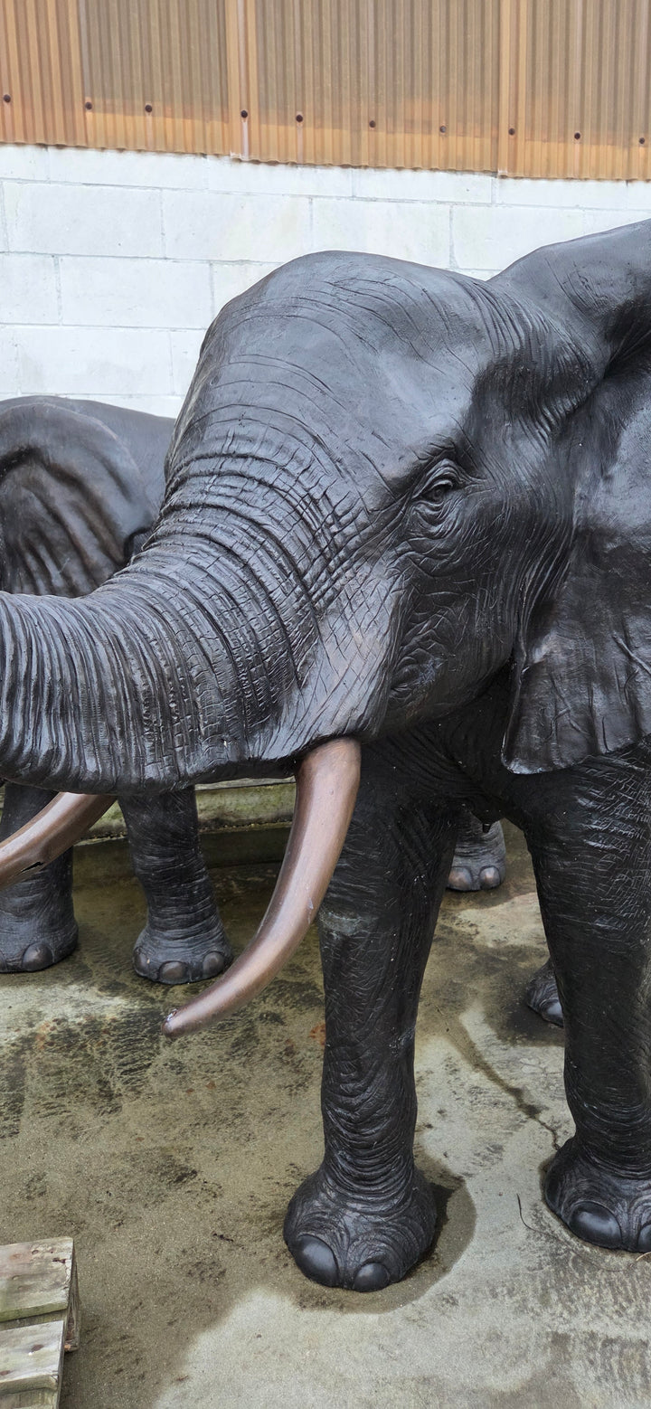 Lifesize bronze sculpture of an elephant with raised trunk