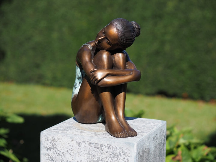 Bronze sculpture of a young girl in swimsuit resting her head