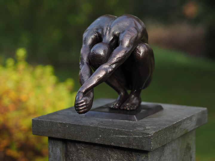 Bronze sculpture of a crouching man in a moment of balance (medium)