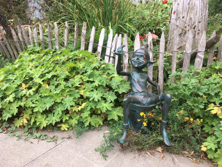 Bronze sculpture of a pixie with a frog sitting in a bucket