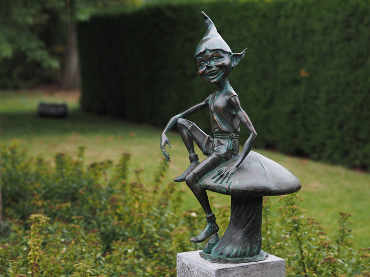 Bronze sculpture of a pixie sitting on a mushroom