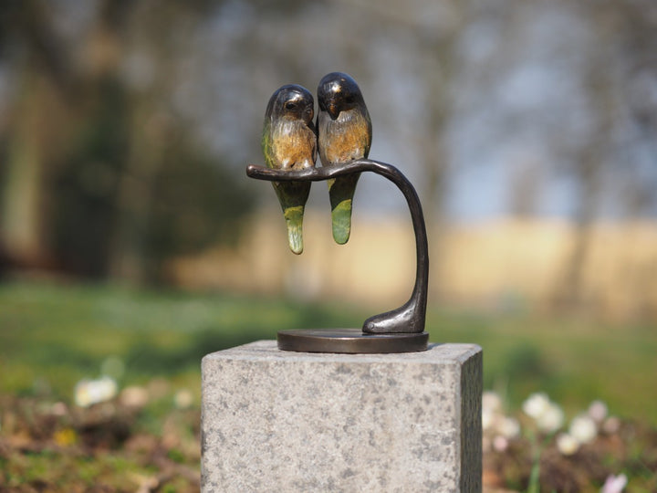 Bronze sculpture of a pair of parakeets on a branch
