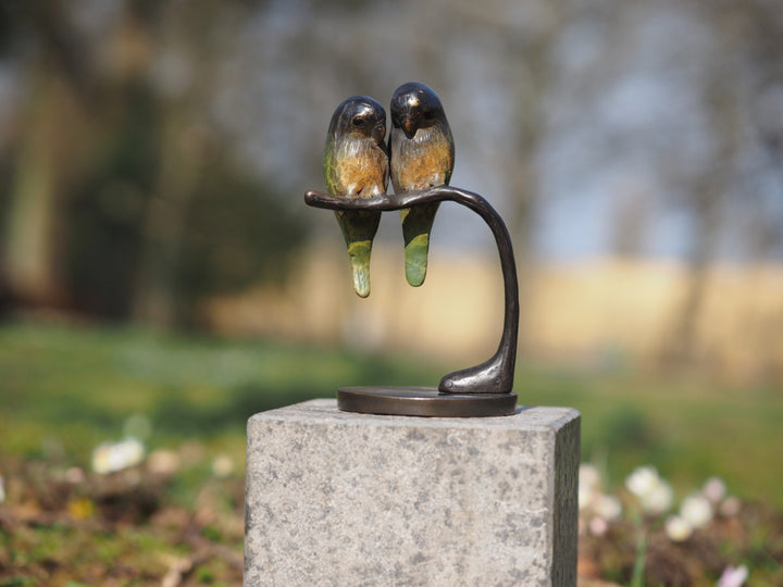 Bronze sculpture of a pair of parakeets on a branch