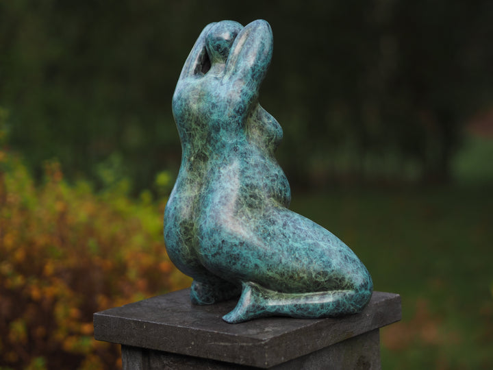 Modern bronze sculpture of a kneeling voluptuous female