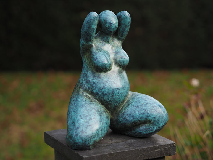 Modern bronze sculpture of a kneeling voluptuous female