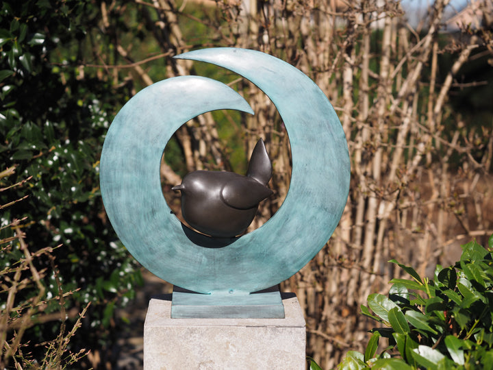 Modern bronze sculpture of a bird sitting in a crescent form
