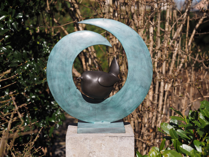 Modern bronze sculpture of a bird sitting in a crescent form