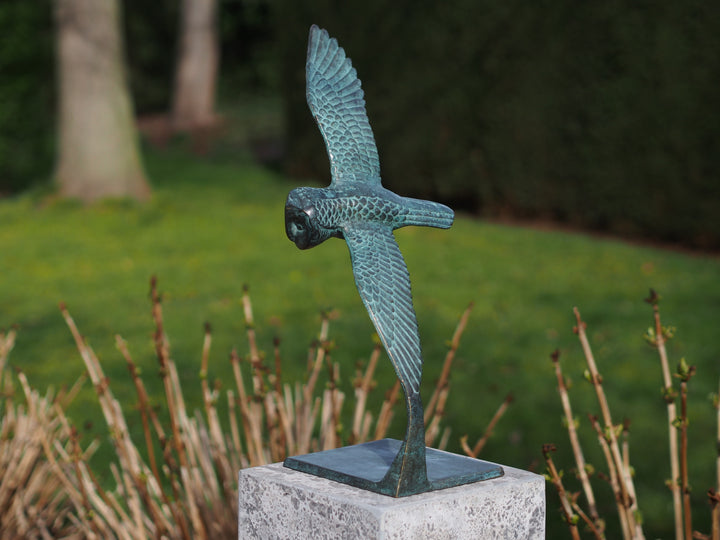 Bronze sculpture of an owl gliding through the air