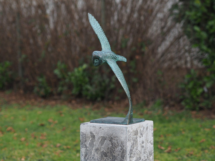 Bronze sculpture of an owl gliding through the air