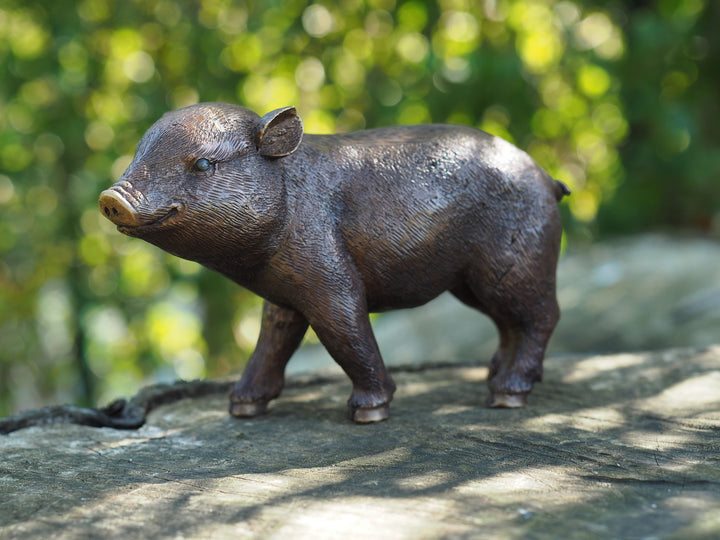 Bronze sculpture of a happy piglet standing