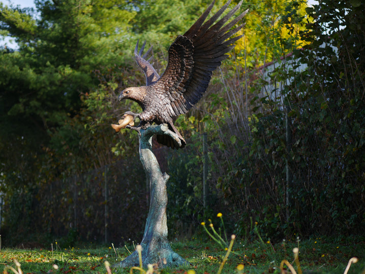 Large bronze sculpture of a landing eagle with fish