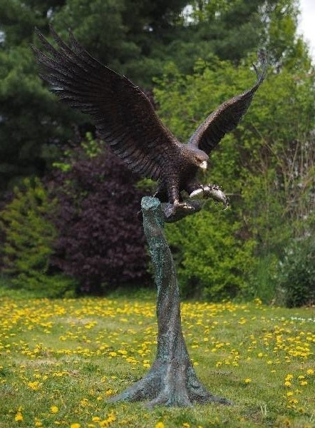 Large bronze sculpture of a landing eagle with fish
