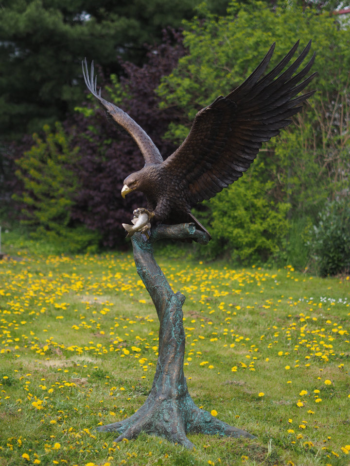 Large bronze sculpture of a landing eagle with fish