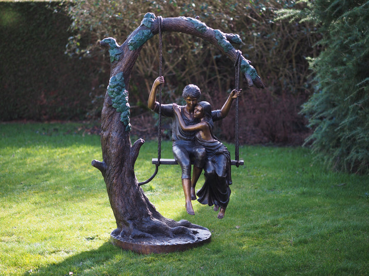 Large bronze sculpture of a young couple on a swing