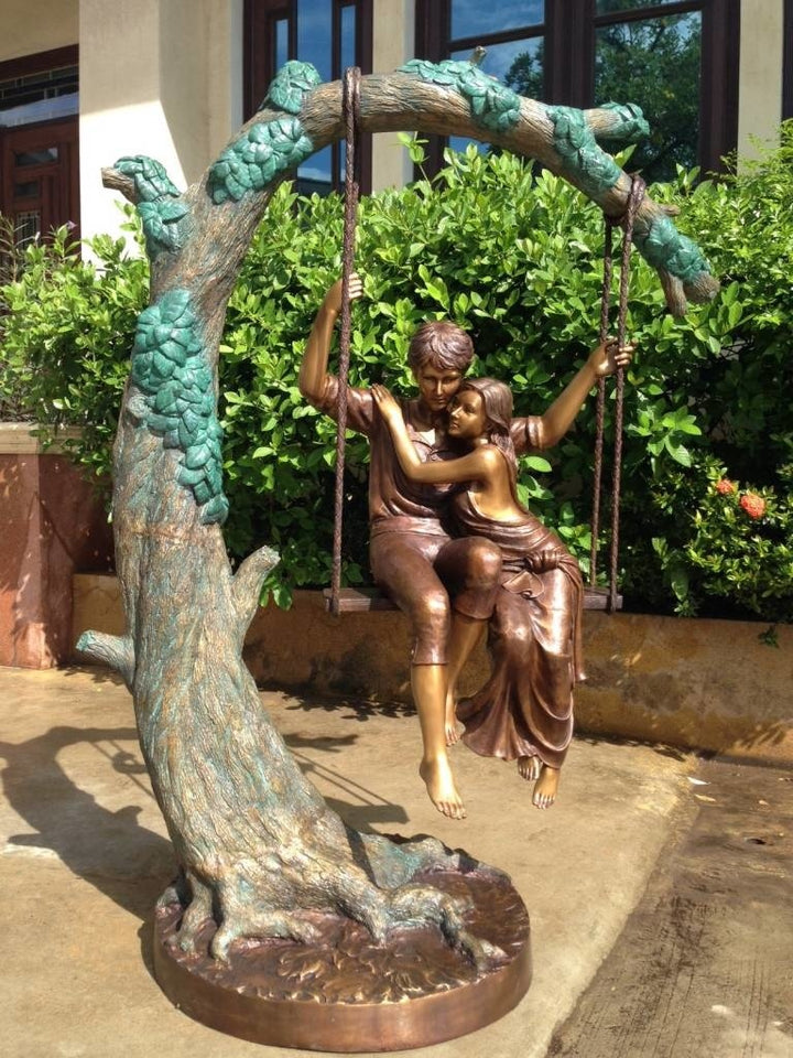 Large bronze sculpture of a young couple on a swing