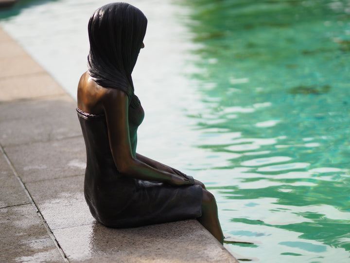 Sculpture en bronze d'une jeune femme assise