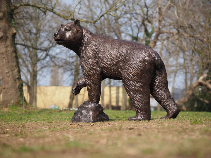 Sculpture de bronze à vie d'un ours avec de la patte surélevée