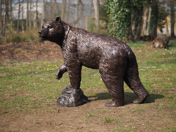 Sculpture de bronze à vie d'un ours avec de la patte surélevée