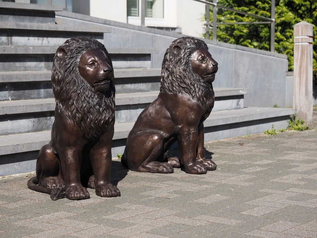 Pair of bronze sitting lion sculptures
