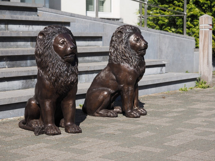 Pair of bronze sitting lion sculptures