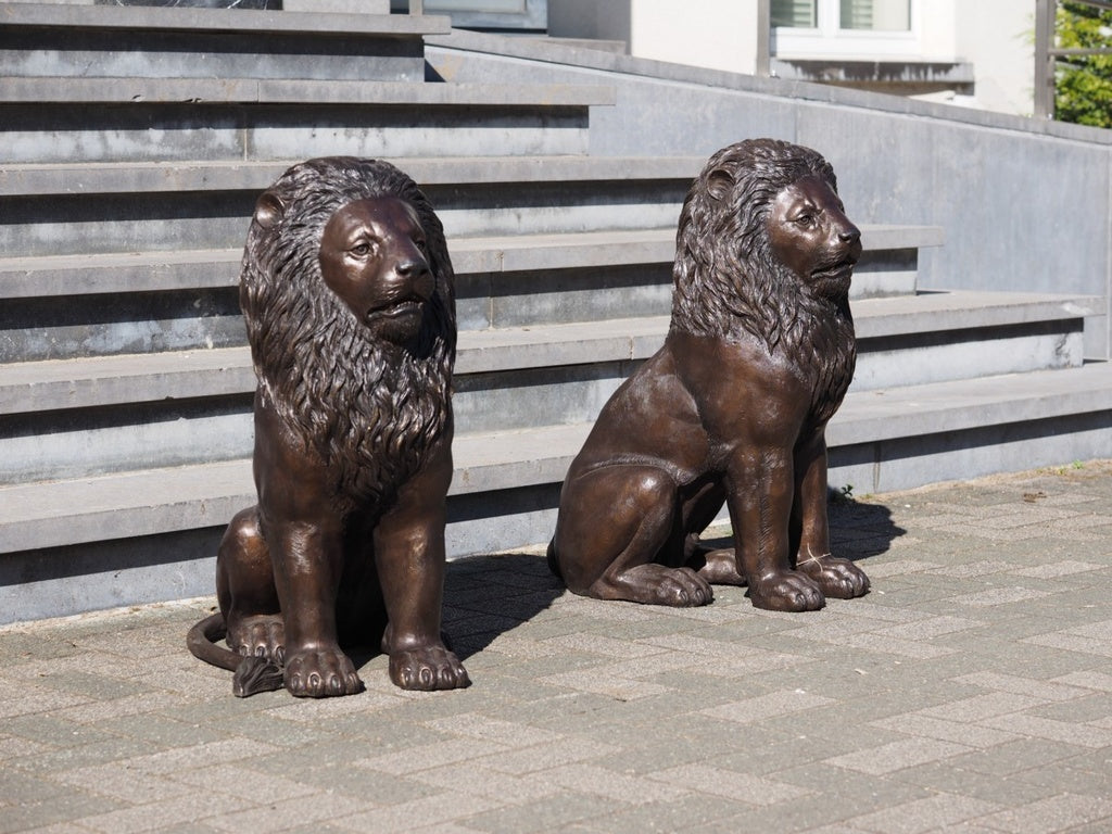 Pair of bronze sitting lion sculptures