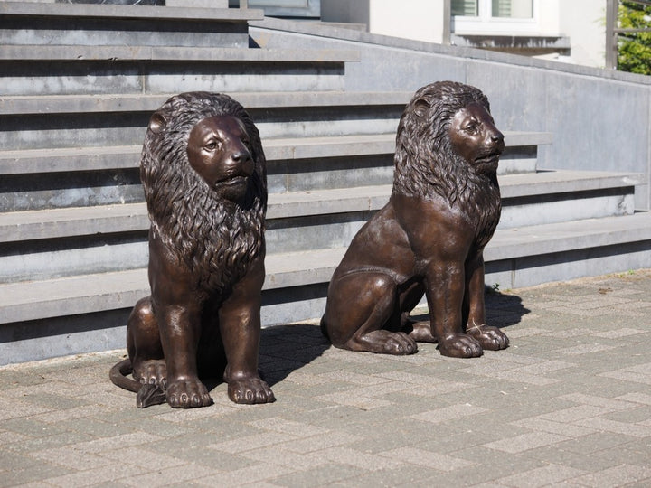 Pair of bronze sitting lion sculptures
