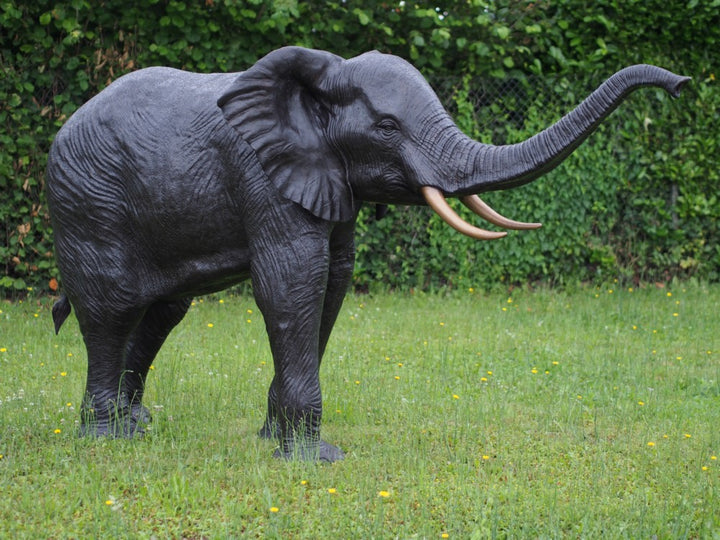 Lifesize bronze sculpture of an elephant with raised trunk