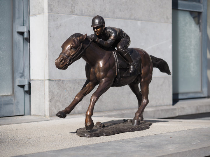Large bronze sculpture of a jockey on horse