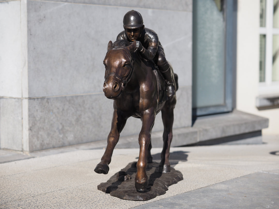 Large bronze sculpture of a jockey on horse