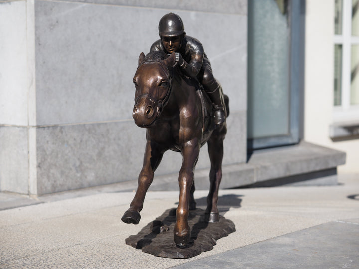 Large bronze sculpture of a jockey on horse