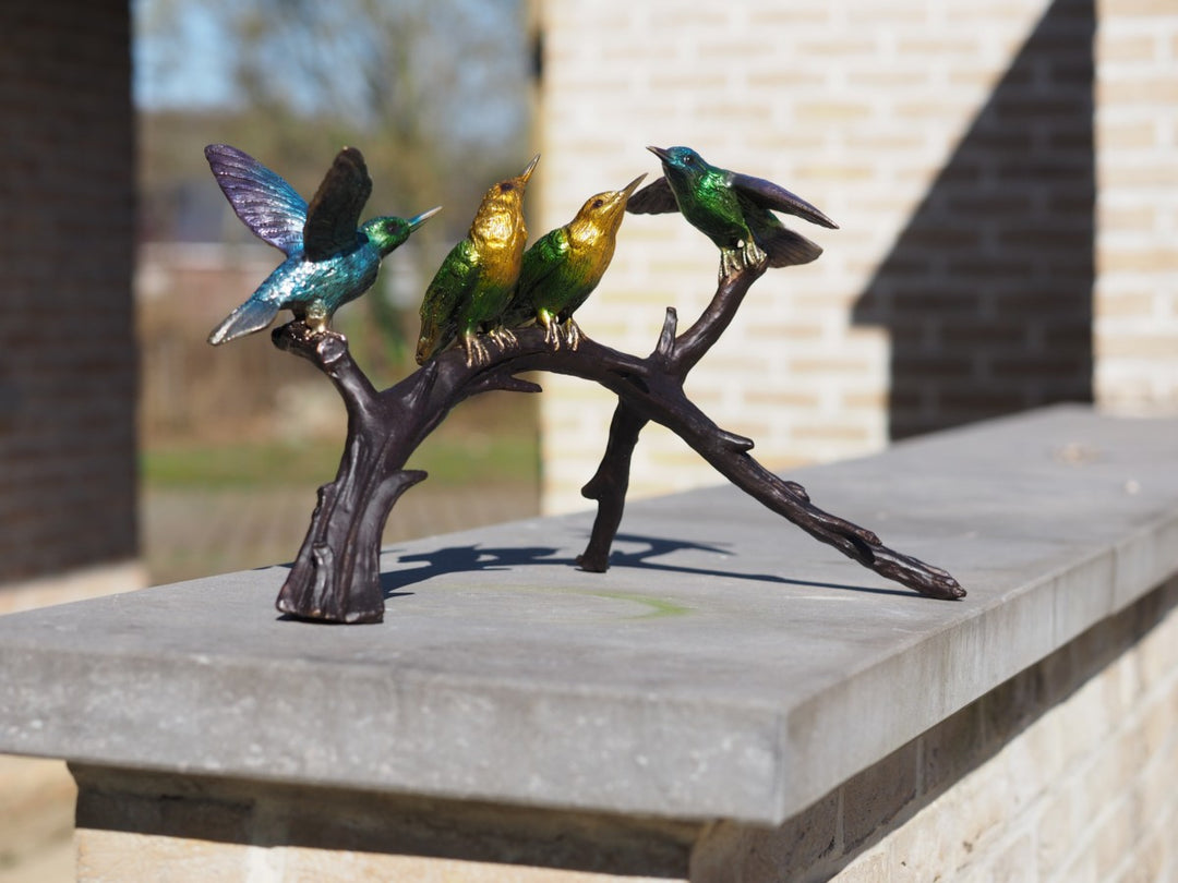 Bronze sculpture of a colourful group of hummingbirds on a branch