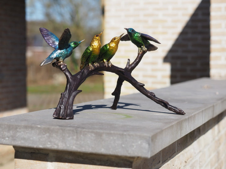 Bronze sculpture of a colourful group of hummingbirds on a branch