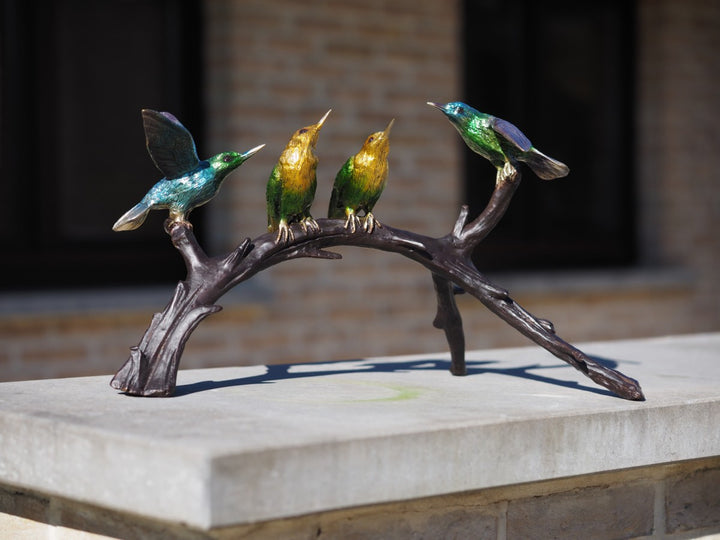 Bronze sculpture of a colourful group of hummingbirds on a branch