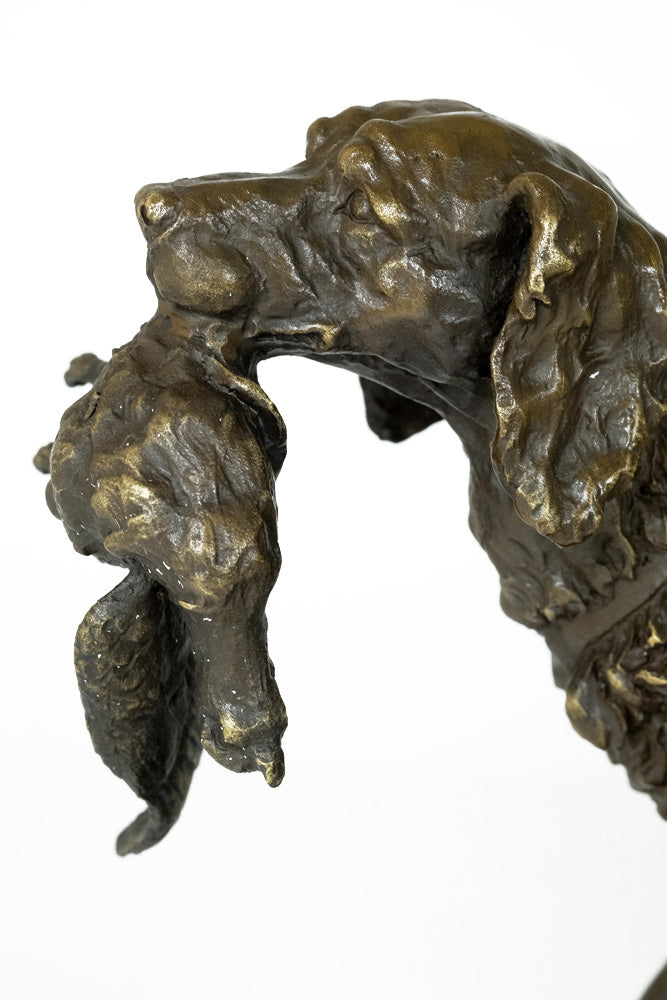 Bronze sculpture of a hunting dog with prey