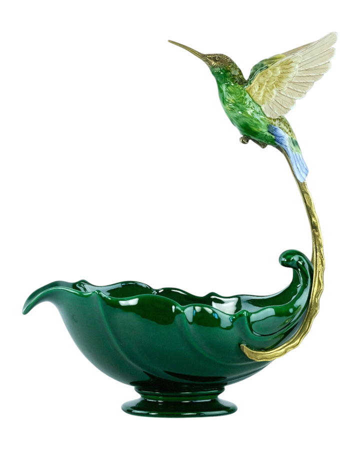 Ciotola di porcellana con un colibrì in bronzo che si libra sopra di essa