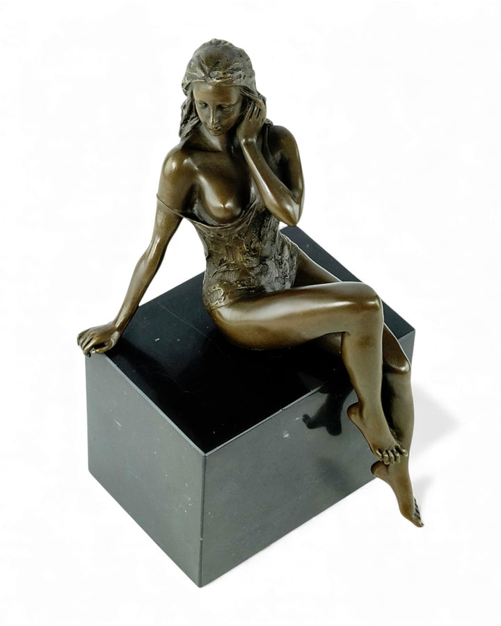 Escultura de bronce de una mujer sentada seductora