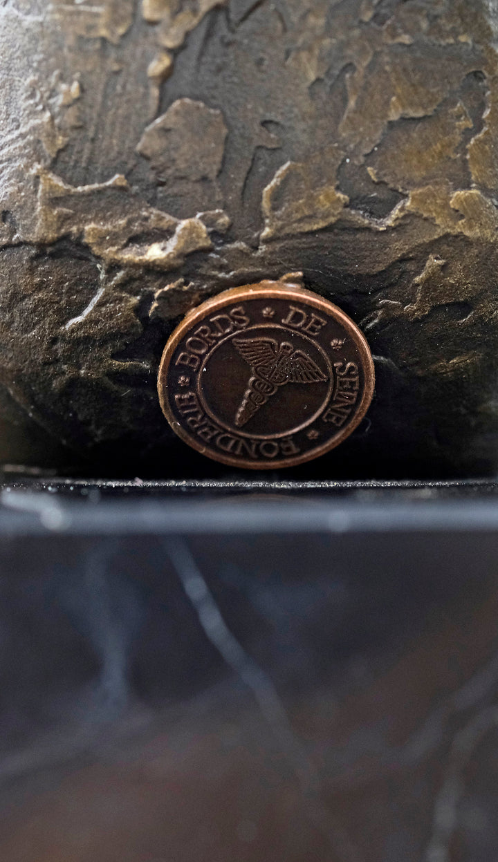 Escultura de bronce de una mujer sentada seductora