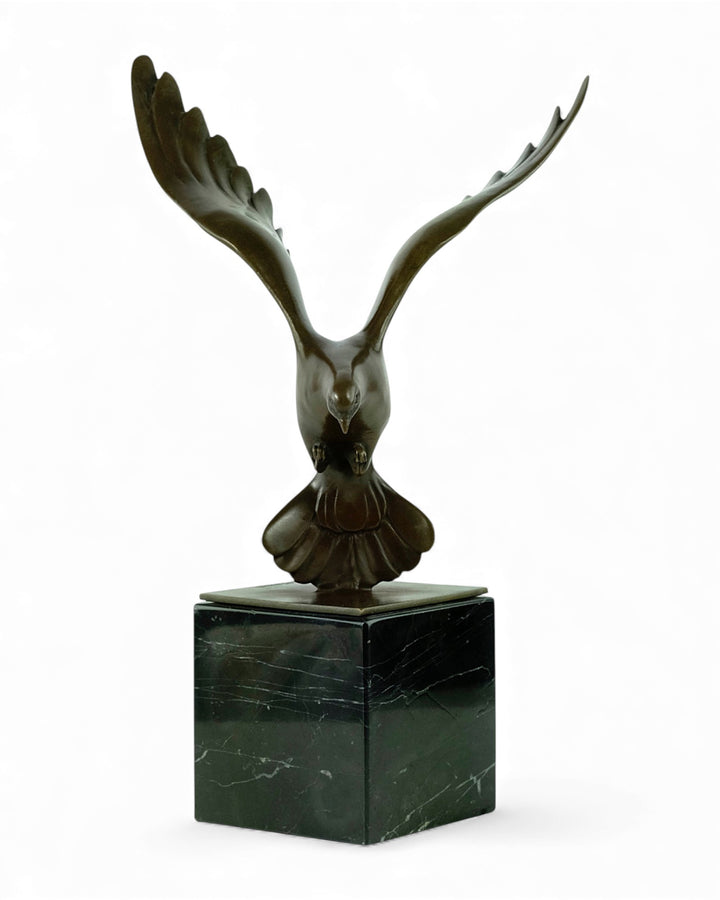 Bronzen sculptuur van een dalende duif met gespreide vleugels