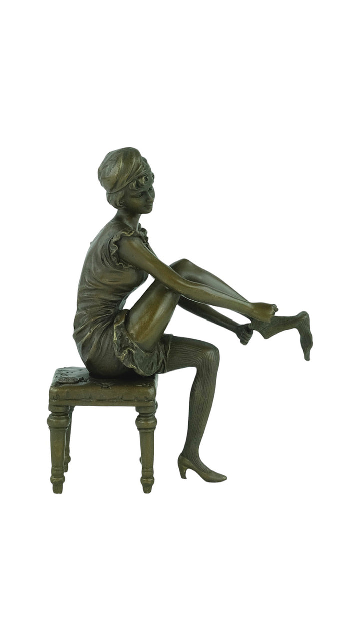 Bronze sculpture of a sitting female putting on stockings