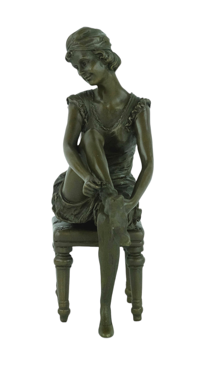 Bronze sculpture of a sitting female putting on stockings