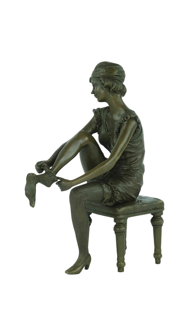 Bronze sculpture of a sitting female putting on stockings