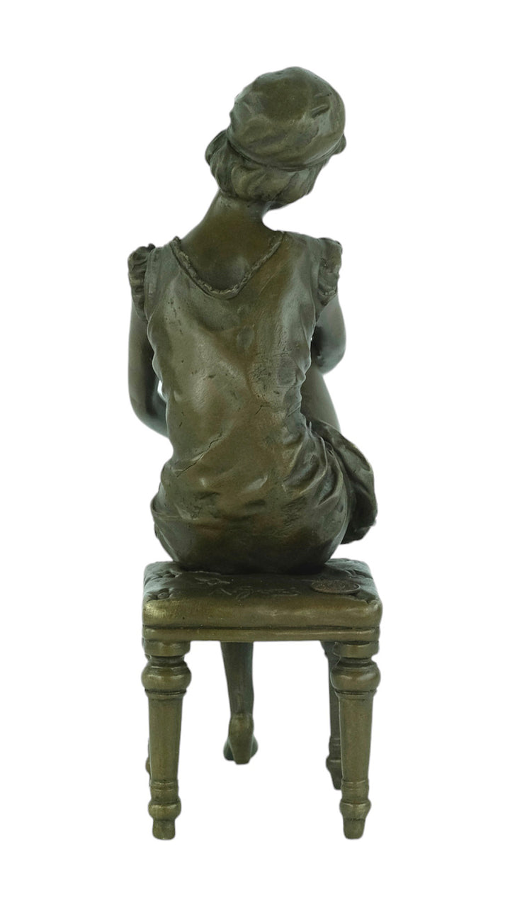 Bronze sculpture of a sitting female putting on stockings