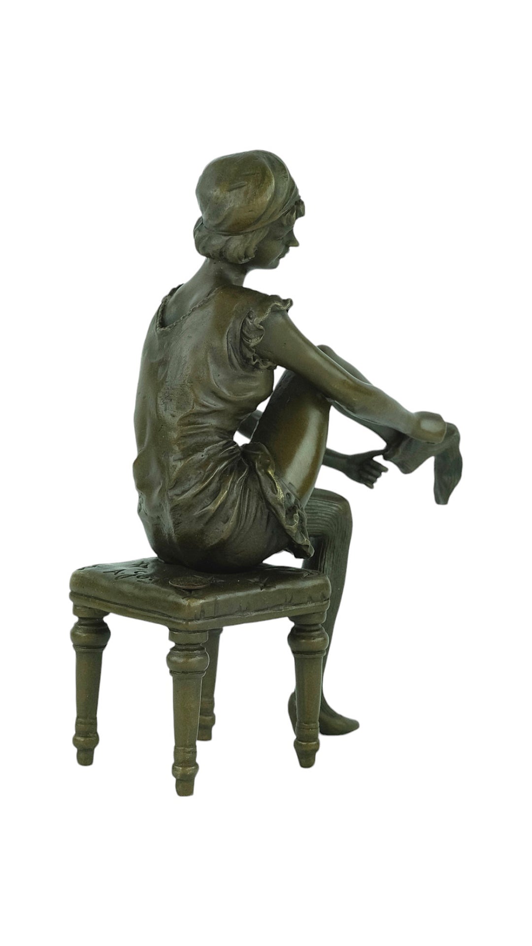 Bronze sculpture of a sitting female putting on stockings