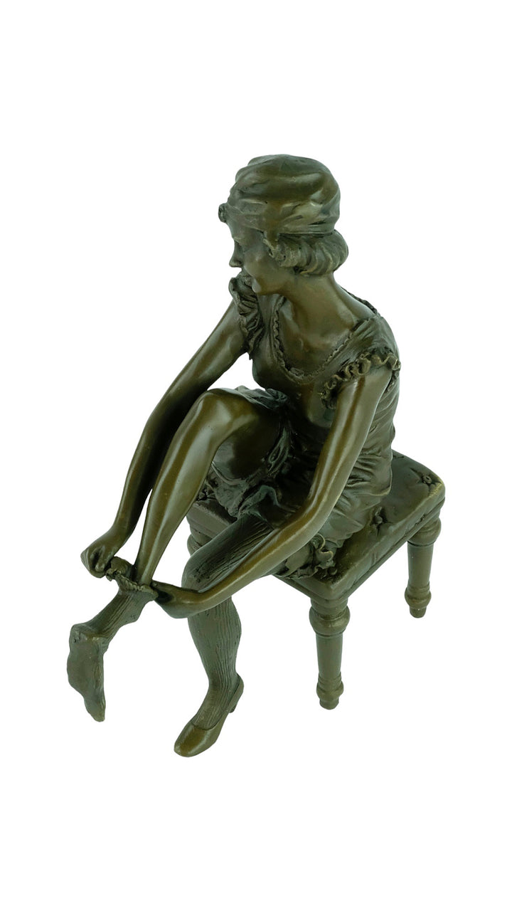 Bronze sculpture of a sitting female putting on stockings