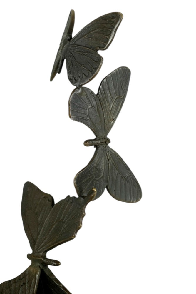 Modern bronzen beeld van een hand die vlinders loslaat